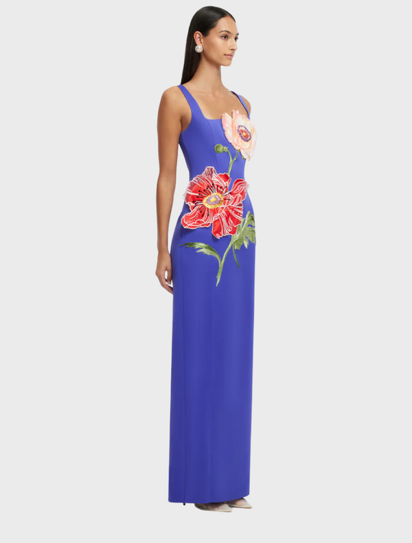 A woman wearing a blue dress, showcasing a stylish design with attention to waist and shoulder details. She is posing as a fashion model.