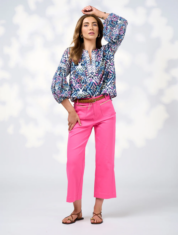 The image features a model wearing a blue and white blouse with a vibrant print, highlighting contemporary fashion trends.