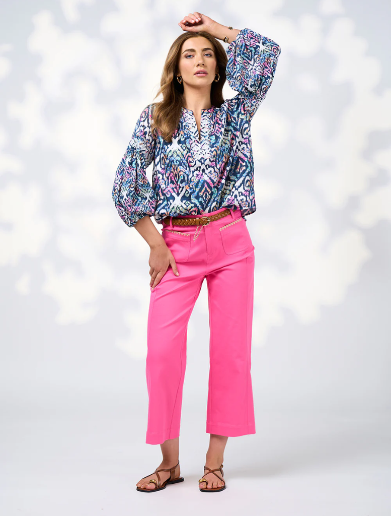 The image features a model wearing a blue and white blouse with a vibrant print, highlighting contemporary fashion trends.