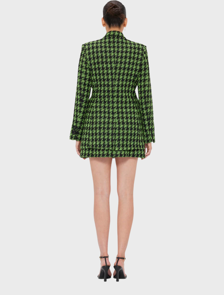 Back view of a woman in a green and black checkered blazer, showcasing the stylish pattern and tailored fit.