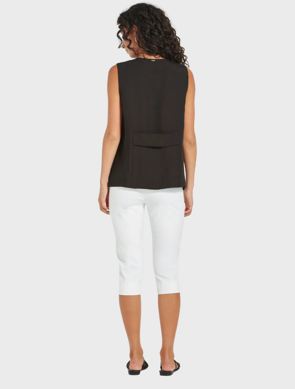 Woman wearing Loretta Vest in black, sleeveless tailored top paired with white cropped pants from Mariko Boutique.