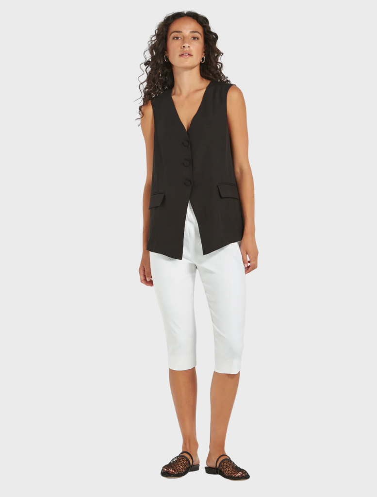 Woman wearing Loretta Vest in black, sleeveless tailored top paired with white cropped pants from Mariko Boutique