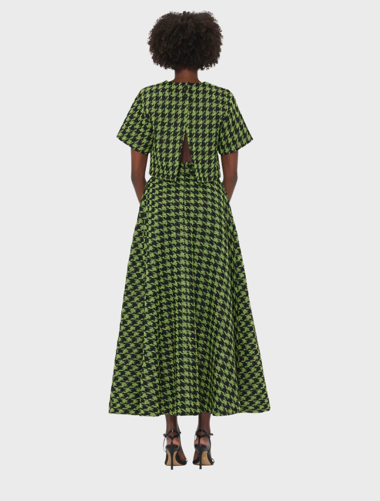 Back view of a woman in a green and black houndstooth maxi dress with short sleeves and a keyhole cutout, paired with strappy heels.