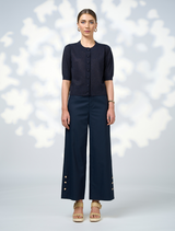 A model showcases a navy cardigan paired with wide-leg pants, highlighting a stylish and relaxed outfit.
