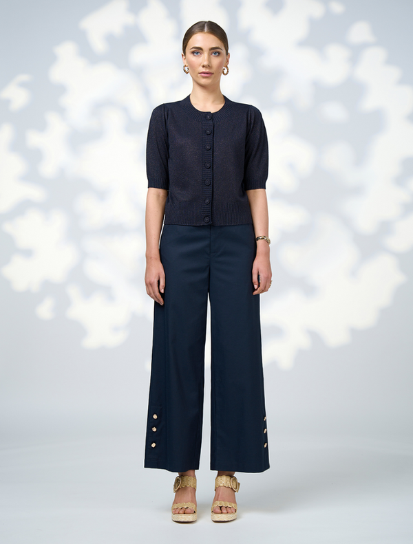 A model showcases a navy cardigan paired with wide-leg pants, highlighting a stylish and relaxed outfit.