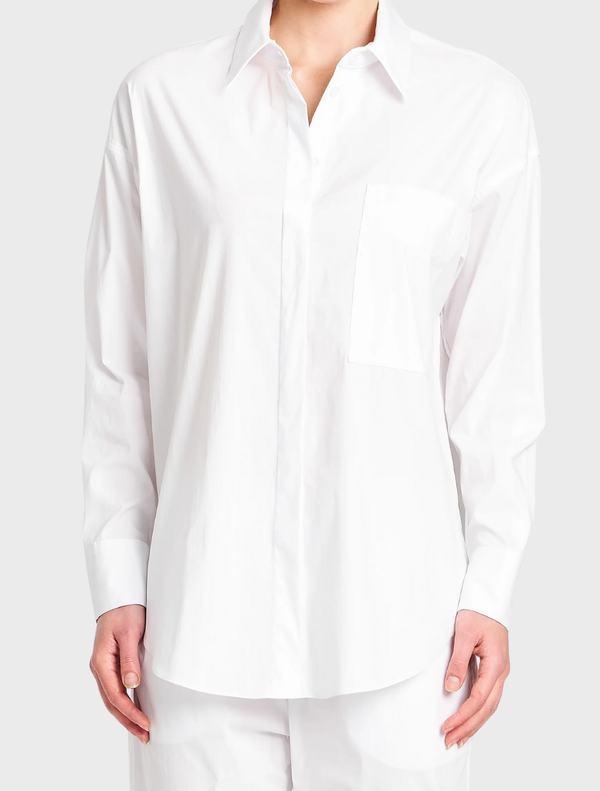 White relaxed pocket shirt displayed on a hanger, featuring a simple design and casual style.