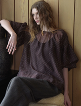 A chocolate-colored blouse with sheer panels, featuring a stylish design suitable for various occasions.