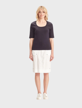 A white Acrobat Legion Skirt hanging on a rack, highlighting its modern style and clean lines.