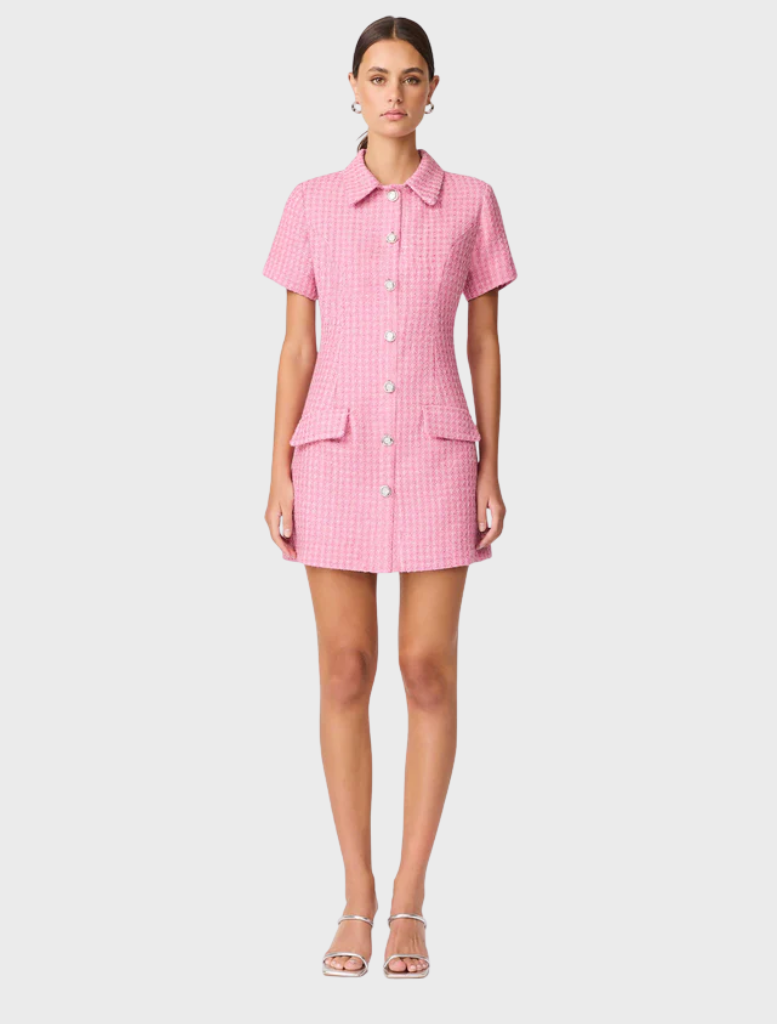 A model showcases a pink shirt dress featuring buttons down the front.
