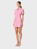 A model wears a stylish pink shirt dress with button details.