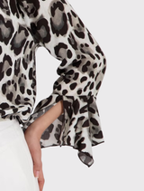 Modern blouse in coffee color with leopard print, round neckline, and ⅞ trumpet sleeves, crafted from soft viscose material.
