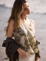 Olive tropical print top featuring a satin finish, round neckline, tank sleeves, and an elastic hem for a stylish summer look.