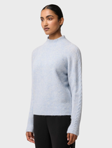 The Blue Frost Savanna Alpaca Blend Sweater draped on a mannequin, emphasizing its relaxed fit and warm color.