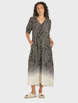 A black and white dress featuring a distinctive pattern, elegantly draped on a mannequin.