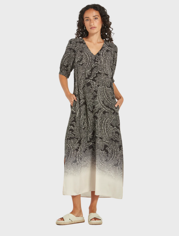 A black and white dress featuring a distinctive pattern, elegantly draped on a mannequin.