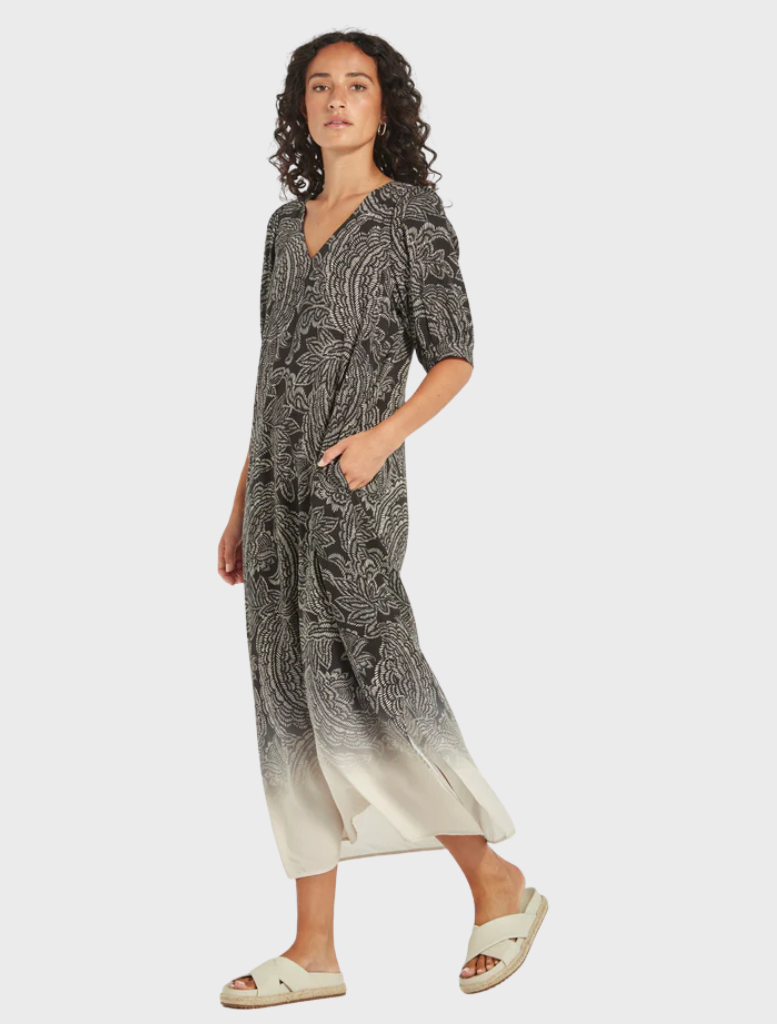 A black and white patterned dress, showcasing a modern design, hanging against a neutral background.