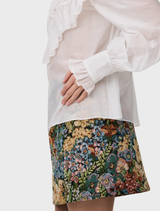 Thea Blouse in Antique, featuring a floral lace bib and ruffle trim, combines silk and cotton for a chic, vintage-inspired outfit.