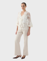 Elegant cream blouse with long sleeves, labeled as Antoinette LS, showcased on a hanger.