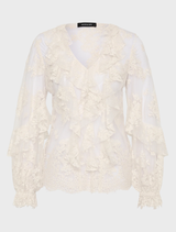 Cream-colored Antoinette LS blouse displayed on a hanger, featuring long sleeves and a stylish design.