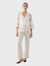 Cream-colored Antoinette LS blouse displayed on a hanger, featuring long sleeves and a stylish design.