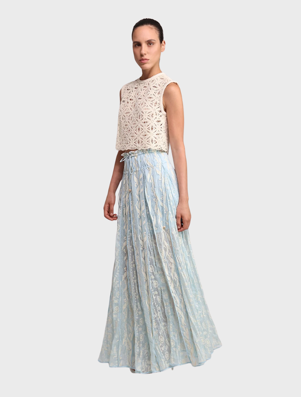 The Malo Skirt in aqua, featuring a soft fabric and elegant silhouette, hangs gracefully on a hanger.