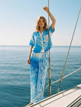 Indigo cropped linen shirt with white botanical prints, classic collar, button-down front, and relaxed silhouette.