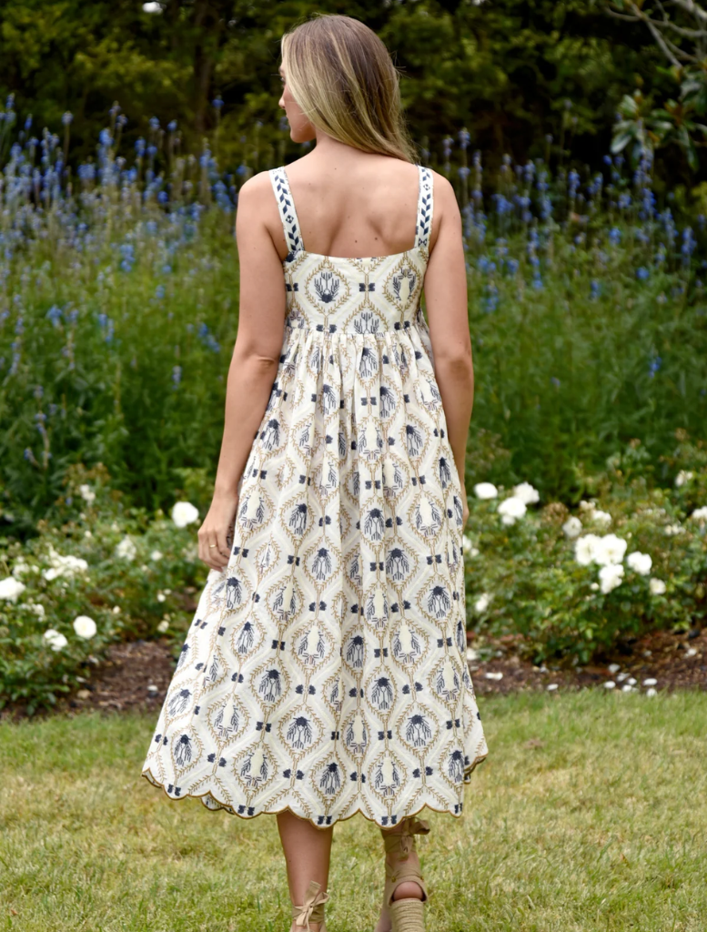A model is dressed in a blue and white floral print dress, featuring a charming design and graceful flow.