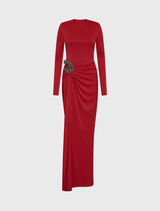Full-length red gown with long sleeves, sculpted bodice, shoulder pads, and hand-embellished details on the skirt.