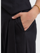  Black pants with a gold bracelet on the wrist, illustrating a sophisticated and fashionable look.