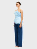 Light blue Tremail top hanging, showcasing a minimalist style and soft fabric ideal for everyday outfits.