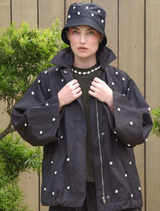 Black Baby I'm Back Jacket displayed on a hanger, showcasing its stylish design and fabric texture.