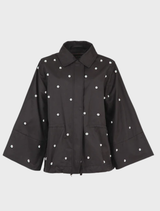 Black Baby I'm Back Jacket displayed on a hanger, showcasing its stylish design and fabric texture.
