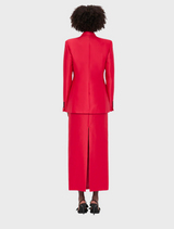 Back view of a woman in a tailored red suit, showcasing a professional and stylish appearance.