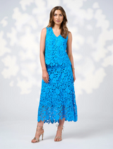 A model displays the Keira Skirt in Baja Blue, featuring a blue lace dress cinched with a belt.