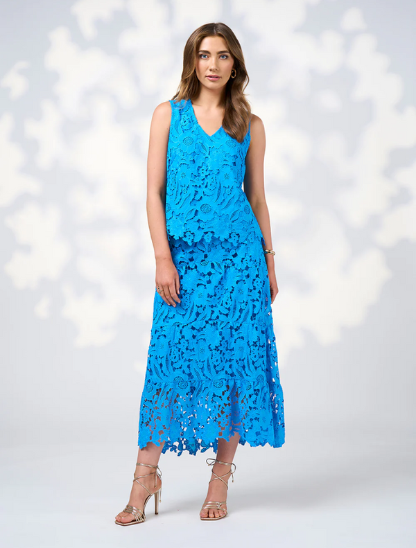 A model displays the Keira Skirt in Baja Blue, featuring a blue lace dress cinched with a belt.