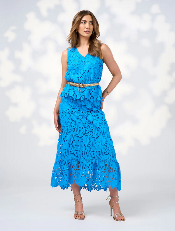 A model displays the Keira Top in Baja Blue, featuring a delicate blue lace dress that highlights elegant design elements.