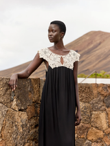 Elegant long dress in black and white viscose georgette, featuring a delicate ecru lace bib and a soft, lightweight silhouette.