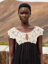 Romantic black and white dress in viscose georgette, highlighted by an ecru lace bib, designed for comfort and style.
