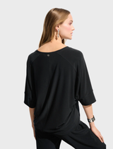  A black top hanging on a hanger, showcasing a classic style with short sleeves.