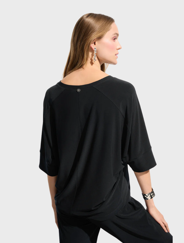  A black top hanging on a hanger, showcasing a classic style with short sleeves.