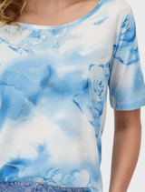  The model is dressed in a blue and white tie-dye shirt, displaying a unique and colorful design.
