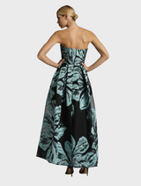 Back view of a woman in a strapless black and green floral dress, showcasing the Bella Gown - Mint Black design