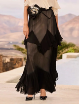 Sophisticated black maxi dress with soft ruffles, cutouts, and a stylish tie-dye flower belt, perfect for special occasions.