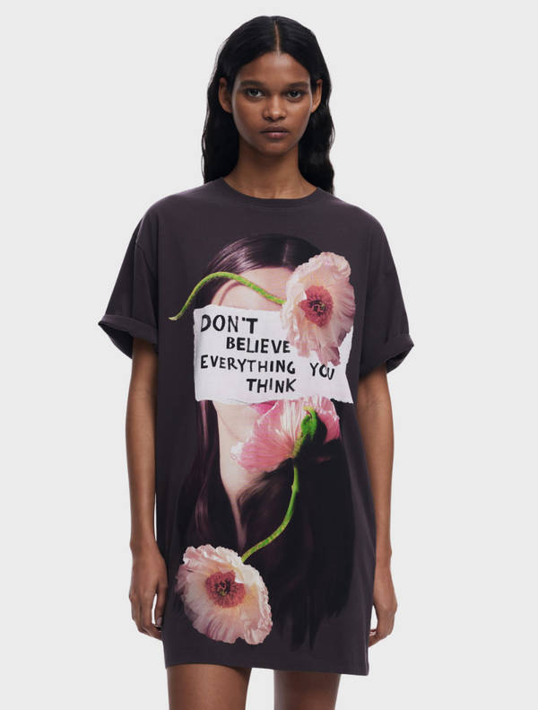 A woman in a t-shirt that reads "don't live everything to" stands confidently, conveying a motivational message.