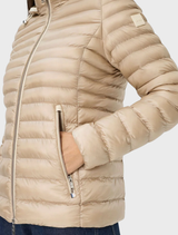 A beige quilted jacket by Bern, featuring a modern cut and intricate stitching, presented on a hanger.