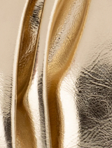 A stylish clutch bag in shiny gold fabric, featuring a metallic finish that adds a touch of glamour.