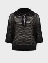 Black top displayed on a hanger, illustrating a chic and understated design.