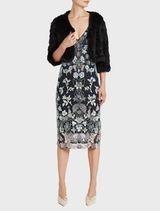 Black fur bolero jacket laid flat, emphasizing its plush material and sophisticated look.