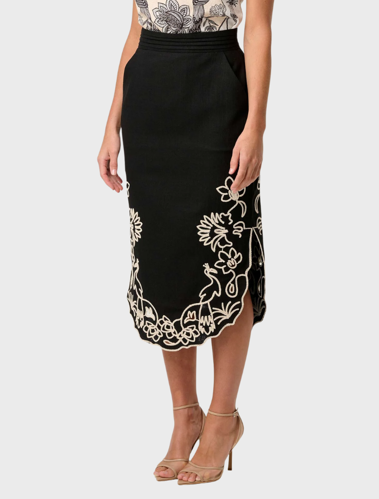 Model presents the Cascadia Embroidered Linen Viscose Midi Skirt in black, adorned with stylish embroidered accents.