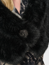 Elegant black cover-up draped on a hanger, highlighting its smooth fabric and minimalist aesthetic.